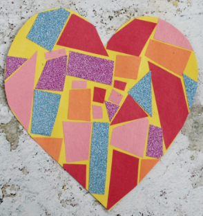 A heart mosiac made of cut out shapes pasted onto a shape of a heart.